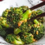 Plate of easy and delicious broccoli with garlic sauce garnished with herbs