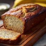 Loaf of easy moist banana bread fresh out of the oven with sliced bananas