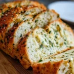 Freshly baked Italian Herb and Cheese Bread with herbs and cheese topping.