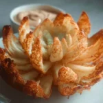 Keto Blooming Onion served with dipping sauce on a plate
