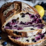 Slice of lemon blueberry sourdough bread on a wooden table