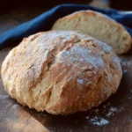 Loaf of freshly baked rustic Italian bread on a wooden cutting board.