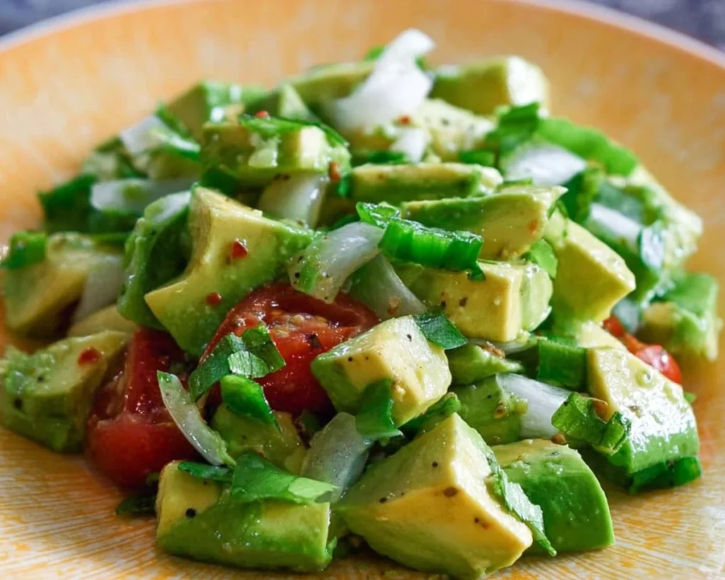 Bowl of easy avocado salad with fresh vegetables and dressing