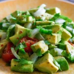 Bowl of easy avocado salad with fresh vegetables and dressing