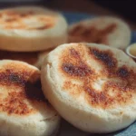 Freshly baked homemade English muffins on a wooden table