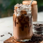 Delicious homemade mocha iced coffee topped with whipped cream and chocolate drizzle.