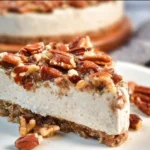 No-Bake Keto Pecan Pie Cheesecake topped with pecans and sugar-free syrup.