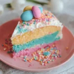 A slice of multi-colored Easter cake on a plate ready to be enjoyed.