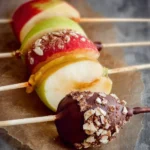 Delicious dipped apple slices on a stick, perfect for snacks or party treats.