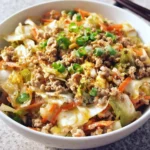 Delicious egg roll in a bowl with colorful vegetables and savory sauce