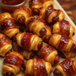 Delicious glazed pigs in a blanket appetizer served on a platter