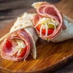 Plate of tasty Italian sub roll-ups filled with assorted meats and vegetables