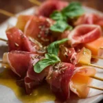 Prosciutto and melon skewers served on a platter
