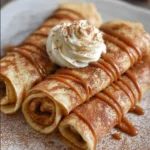 Delicious cinnamon roll protein crepes topped with creamy frosting
