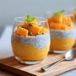 Creamy papaya and mango chia pots garnished with fresh fruit.