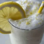 Refreshing frozen lemonade served in a glass with ice and lemon slices.