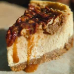 Slice of pecan pie cheesecake topped with pecans and caramel drizzle
