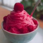 Delicious bowl of Raspberry Frozen Yogurt topped with fresh raspberries