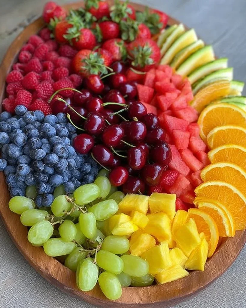 Colorful rainbow fruit platter with cherries, blueberries, and more healthy snacks