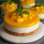 No bake mango cheesecake topped with fresh mango slices and whipped cream