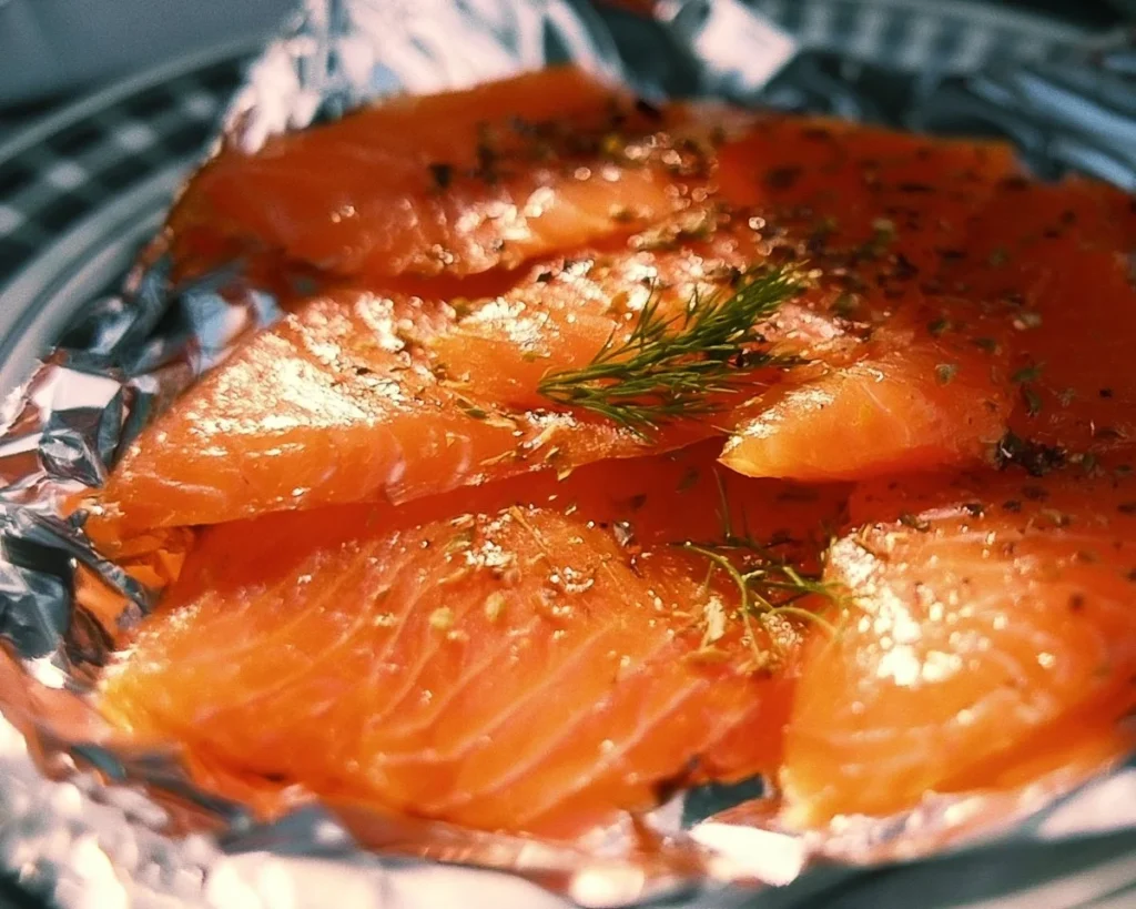 Delicious smoked salmon garnished with herbs and lemon slices.