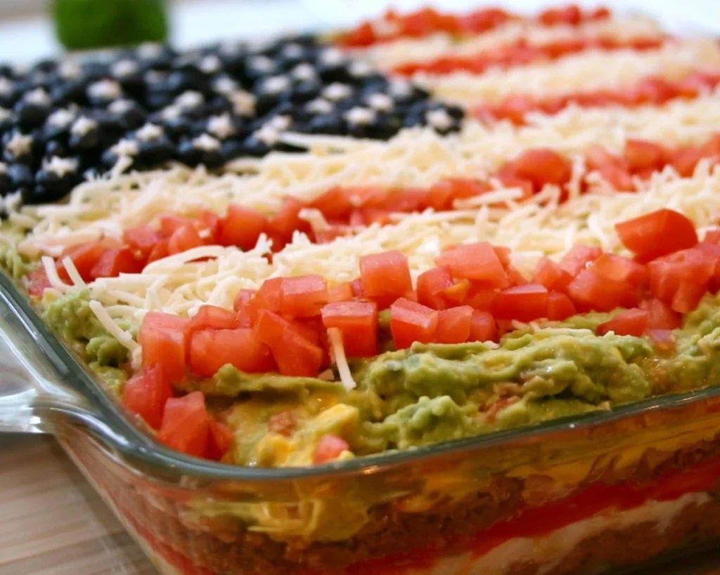 American Flag Layered Taco Dip served in a decorative bowl for festive occasions