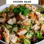 A bowl of fresh chicken salad with vegetables and dressing