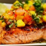 Delicious fresh salmon fillet served with mango salsa on a plate