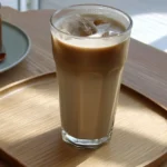 Iced Maple Hojicha Latte in a glass with maple syrup drizzle.