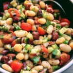 Colorful Mediterranean Bean Salad with beans, vegetables, and herbs in a bowl.