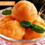 Delicious peach sorbet served in a bowl with fresh peaches as garnish