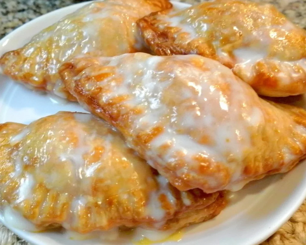 Delicious glazed peach hand pies with fresh peach filling and golden crust