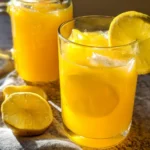 A refreshing glass of mango lemonade with slices of lemon and fresh mangoes