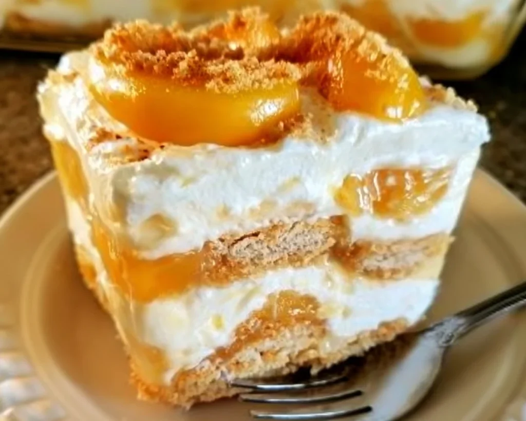 No-bake peach yum yum dessert served in a glass dish with fresh peaches