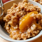 Delicious serving of old-fashioned peach crisp with golden topping