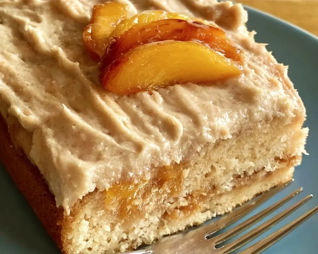 Delicious Peach Cake with Brown Sugar Frosting on a white plate