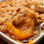 Delicious Southern peach cobbler served in a dish, topped with ice cream.