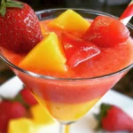 Glass of Virgin Strawberry Mango Daiquiri with fresh strawberries and mangoes